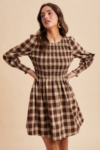 Woman wearing a plaid dress on a beige background