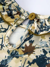 Load image into Gallery viewer, Close-up of a floral-patterned shirt with a button on a white background