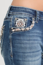 Load image into Gallery viewer, Close-up of blue jeans with decorative pocket design on a white background