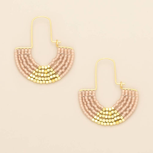 Pair of beaded earrings with gold accents on a beige background