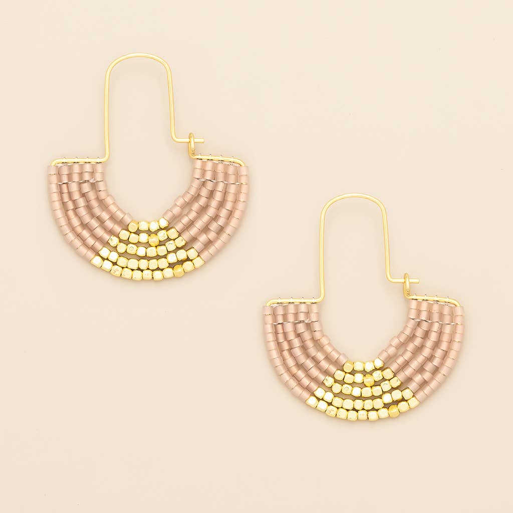 Pair of beaded earrings with gold accents on a beige background