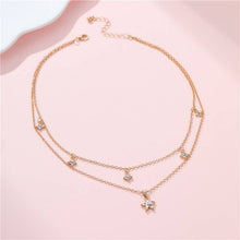 Load image into Gallery viewer, Rose gold necklace with small pendants on a pink background