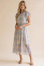 Load image into Gallery viewer, Woman wearing a floral dress against a beige background