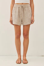 Load image into Gallery viewer, Person wearing beige plaid shorts on a white background