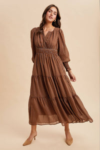 Woman wearing a brown patterned dress on a beige background