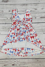 Load image into Gallery viewer, White dress with red, blue, and white floral and bow pattern on a wooden surface