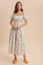Load image into Gallery viewer, Woman wearing a floral dress against a beige background