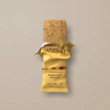 Load image into Gallery viewer, Protein bar with banana spice rum cake flavor packaging on a beige background