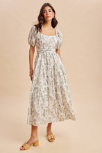 Load image into Gallery viewer, Woman wearing a floral dress against a beige background