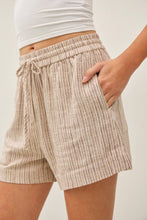 Load image into Gallery viewer, Person wearing beige striped shorts with a white background