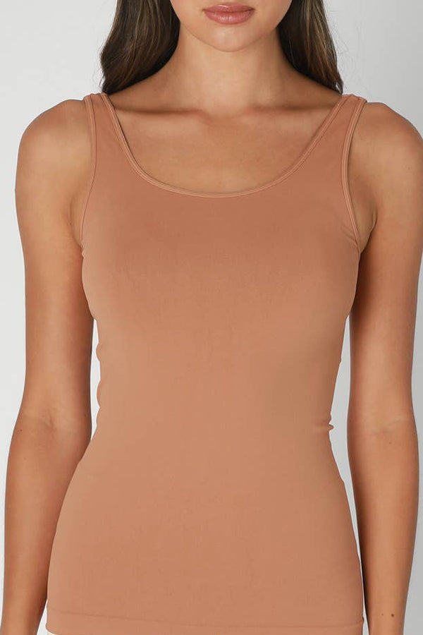 Woman wearing a brown tank top against a plain background