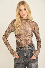 Load image into Gallery viewer, Woman wearing a camouflage long-sleeve top and patterned pants on a beige background