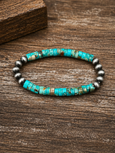 Load image into Gallery viewer, Turquoise beaded bracelet with silver accents on a wooden surface