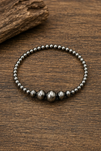 Load image into Gallery viewer, Silver beaded bracelet on a wooden surface