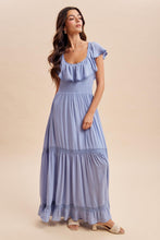 Load image into Gallery viewer, Woman wearing a blue dress against a beige background