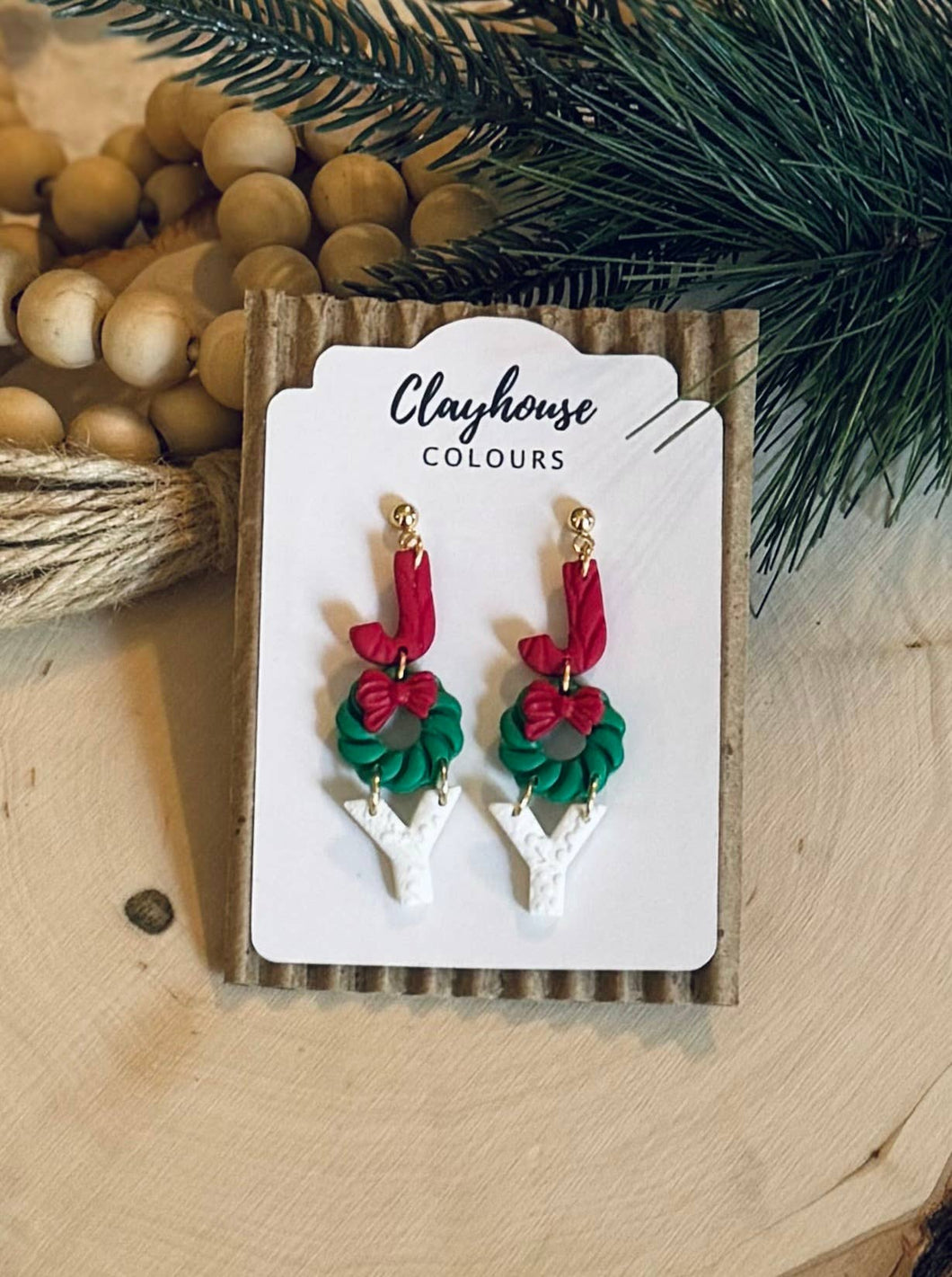 Christmas-themed earrings on a 'Clayhouse Colours' branded card with decorative background