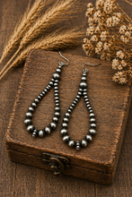 Load image into Gallery viewer, Pair of silver beaded earrings on a wooden box with dried plants.