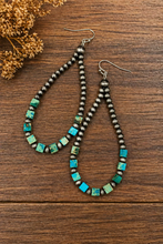 Load image into Gallery viewer, Pair of beaded earrings on a wooden surface with dried flowers.