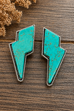 Load image into Gallery viewer, Turquoise arrowhead-shaped earrings on a wooden surface with dried plants.