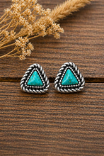 Load image into Gallery viewer, Pair of triangle-shaped earrings with turquoise stones on a wooden surface.