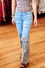 Load image into Gallery viewer, Woman in a clothing store wearing a sleeveless top and ripped jeans.