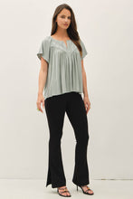 Load image into Gallery viewer, Woman wearing a light green blouse and black pants on a white background