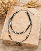 Load image into Gallery viewer, Two beaded necklaces on a wooden box with a rustic background