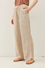 Load image into Gallery viewer, Person wearing beige striped pants on a white background