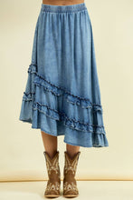 Load image into Gallery viewer, Blue denim skirt with ruffles worn by a person, paired with brown cowboy boots on a beige background.