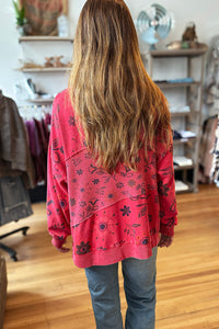 girl wearing red sweatshirt with floral print