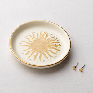 Decorative plate with a sun design on a light gray background
