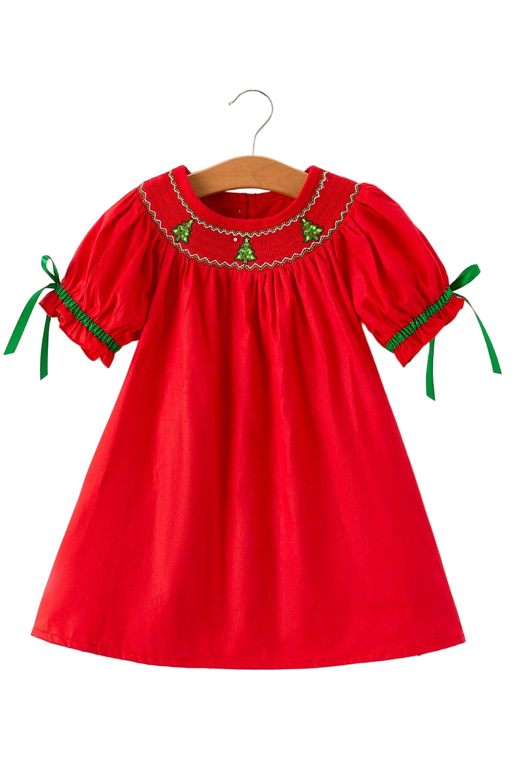 Red dress with green accents on a wooden hanger against a white background