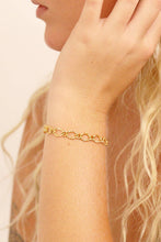 Load image into Gallery viewer, Gold bracelet on a person's wrist with a neutral background