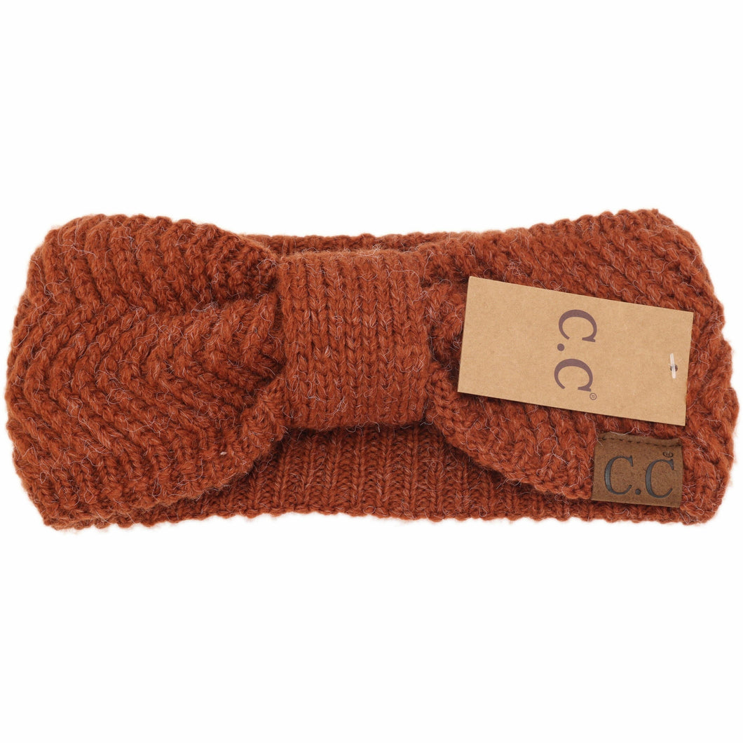 Brown knitted headband with a visible brand tag on a white background