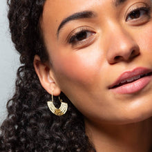Load image into Gallery viewer, Close-up of a woman wearing gold hoop earrings with a neutral background