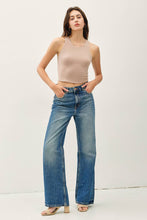 Load image into Gallery viewer, Woman wearing a beige tank top and blue jeans on a white background