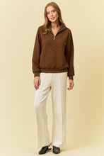 Load image into Gallery viewer, Woman wearing a brown patterned sweater and white pants on a beige background