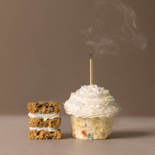 Load image into Gallery viewer, Small cake and cupcake with a lit candle on a brown background