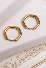 Load image into Gallery viewer, Gold hoop earrings on a textured white surface