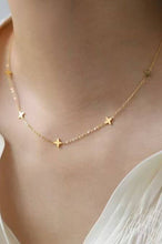 Load image into Gallery viewer, Gold star necklace on a person wearing a white top