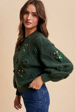 Load image into Gallery viewer, Woman wearing a green embroidered sweater against a beige background