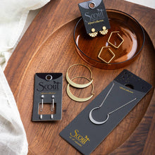Load image into Gallery viewer, Jewelry set including earrings, a necklace, and hoop earrings on Scout branded cards and display stand.