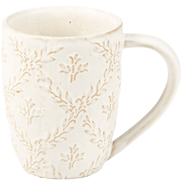 White ceramic mug with subtle leaf pattern on a white background