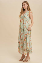 Load image into Gallery viewer, Woman wearing a floral dress against a beige background