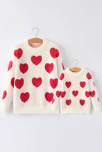 Load image into Gallery viewer, Two cream-colored sweaters with red heart patterns on hangers against a white background