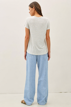 Load image into Gallery viewer, woman wearing light blue jeans with grey background