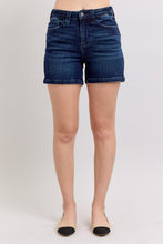 Load image into Gallery viewer, Person wearing dark blue denim shorts on a plain background
