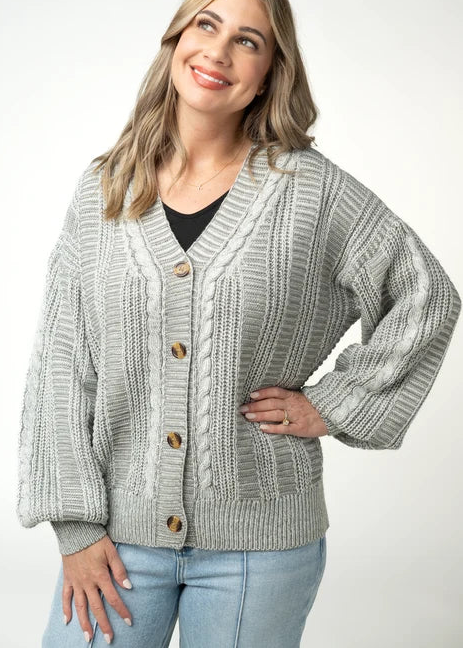 woman wearing cable knit cardigan in grey studio background