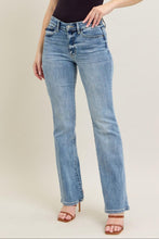 Load image into Gallery viewer, Woman wearing a black t-shirt and blue jeans on a plain background