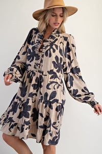 Woman wearing a floral dress and beige hat against a white background